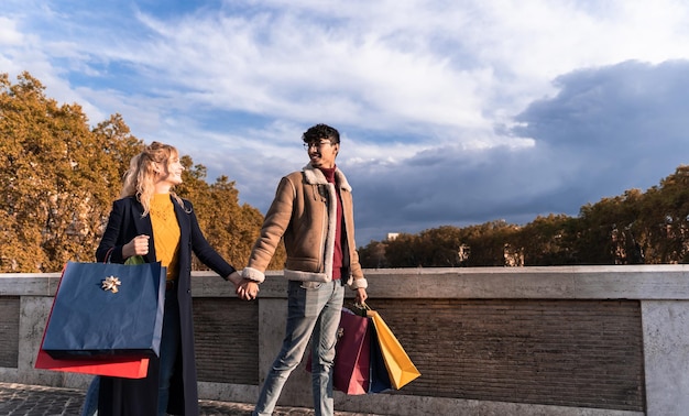 Young couple walking in town with shopping bags shopping time
autumn and winter season