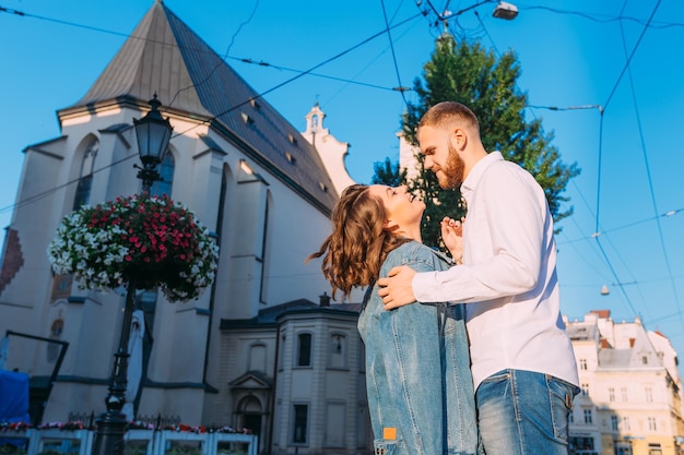 A young couple walks around the city in the morning a girl smiles at a man wears a denim jacket