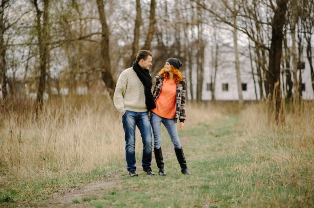 Young couple walks in autumn forest.