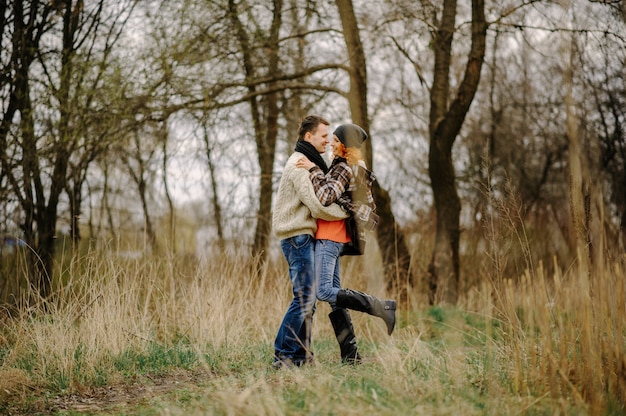 Young couple walks in autumn forest.