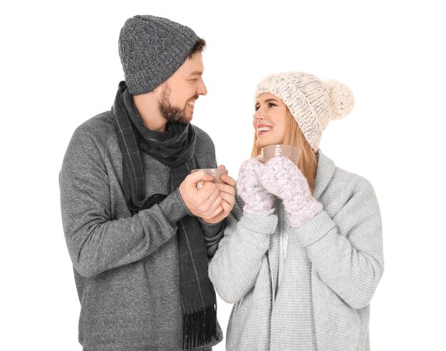 Young couple in warm clothing on white surface