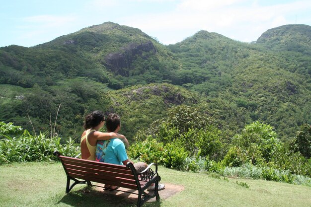 Photo young couple watching tropical rainforest from elevated spot