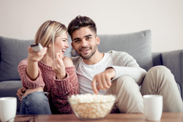 Young couple watching tv on sofa