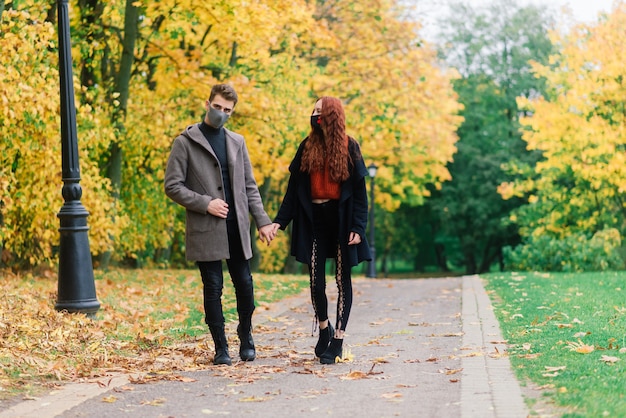 Young couple wearing masks together  in the park