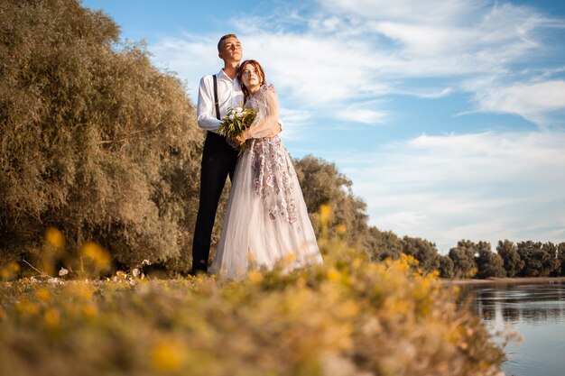 Giovane coppia il giorno del matrimonio in riva al lago