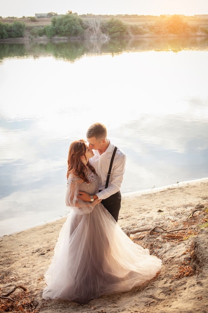湖のほとりの結婚式の日の若いカップル