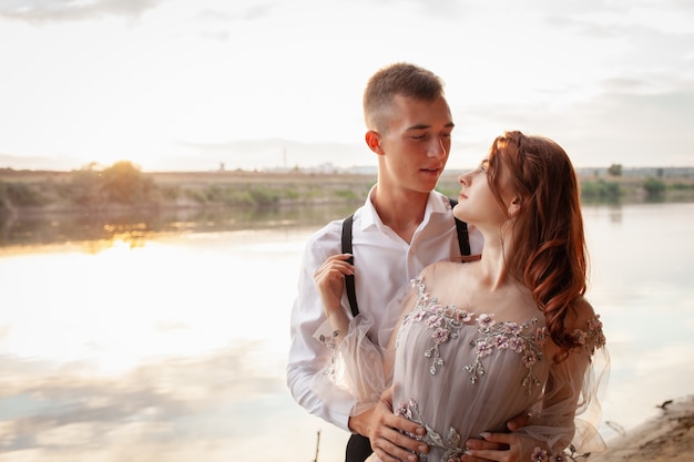 Young couple on the wedding day by the lake