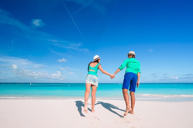 Молодая пара на белом пляже во время летних каникул.