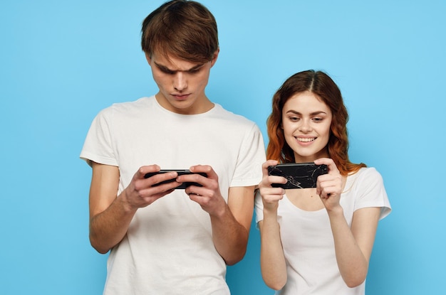 young couple in white tshirts with phones in hands technology high quality photo