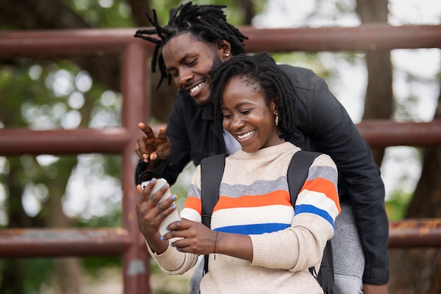 Foto giovani coppie con i dreadlocks afro che prendono selfie all'aperto