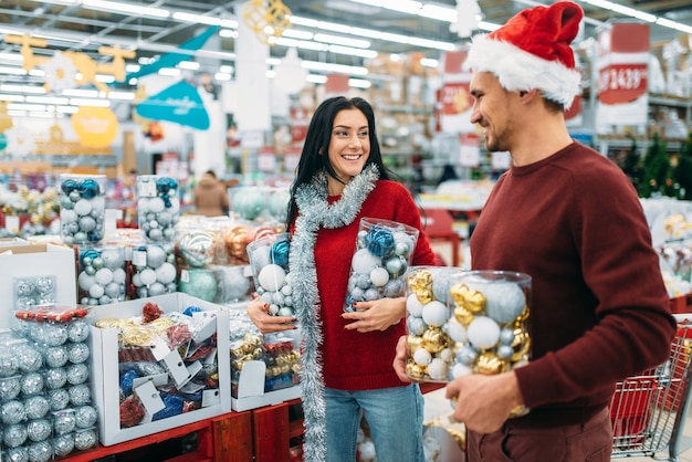 クリスマスボールでいっぱいの箱を持つ若いカップル