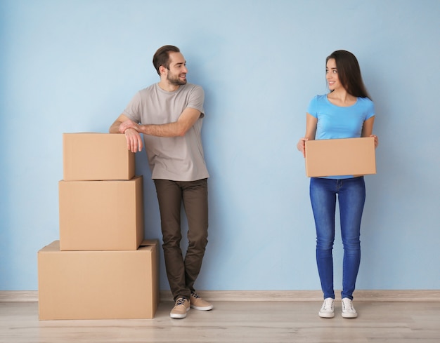 Young couple with boxes indoors. Moving into new house