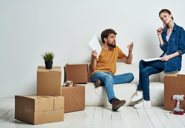 Young couple with boxes of things tools room interior