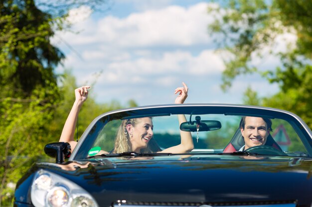 Young couple with cabriolet in summer on day trip