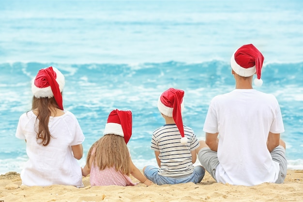 Young couple with children on beach. Christmas concept