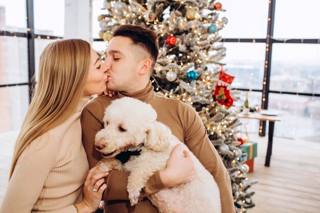 Young couple with dog and Christmas tree,