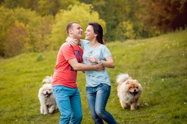 Young couple with the dogs in the park