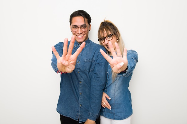 Young couple with glasses happy and counting four with fingers