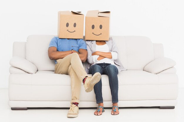 Young couple with happy smiley boxes over faces