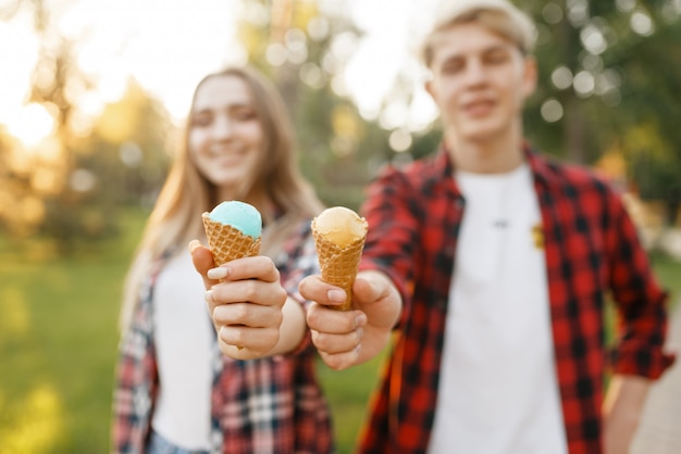 夏の公園を歩いてアイスクリームと若いカップル。