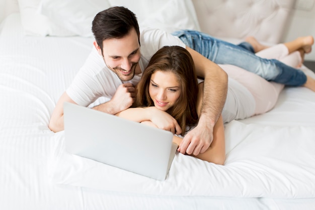 Young couple with laptop in the bed