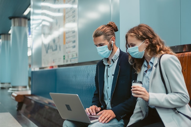 Young couple with a laptop on the subway platform . photo with a copy-space.