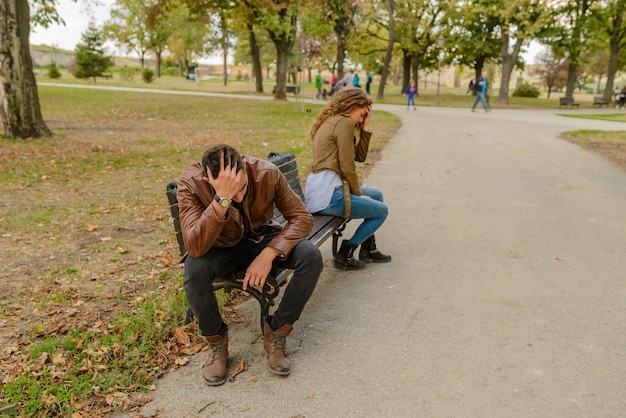 Photo young couple with the love problems sitting in the city park