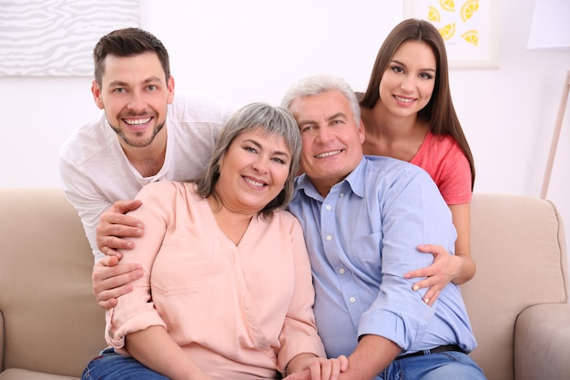 Young couple with middle aged parents on sofa in the room