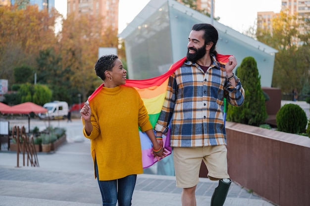 LGTBI 사람들의 권리를 옹호하는 무지개 깃발을 든 젊은 부부 개념 자부심 권리 기호