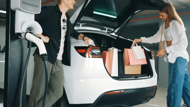 Photo young couple with shopping bag travel by ev electric innards