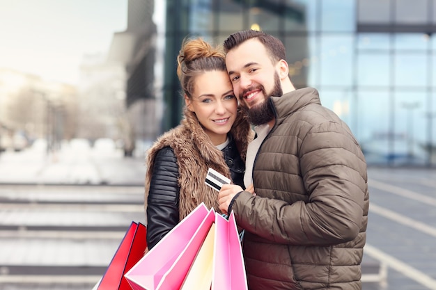 young couple with shopping bags and credit card in the city