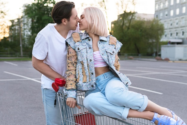 Young couple with a shopping trolley on supermarket parking