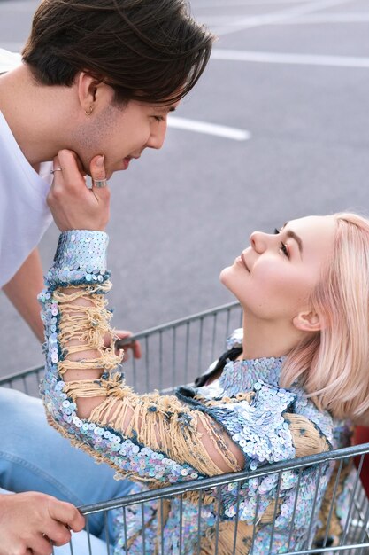 Young couple with a shopping trolley in supermarket parking