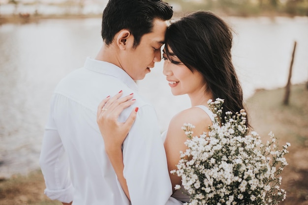 young couple with white flowers romancing outdoors