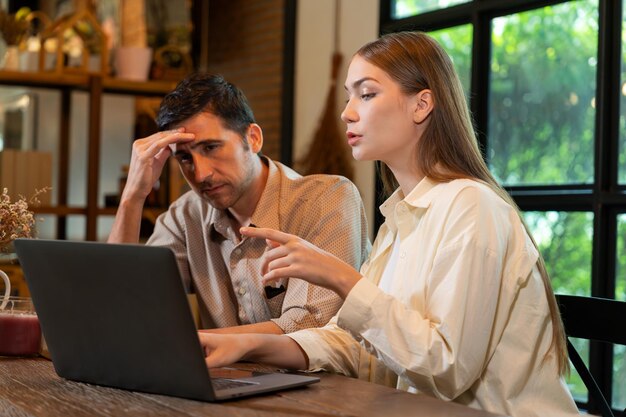 young couple working remotely on laptop in cafe look tired expedient