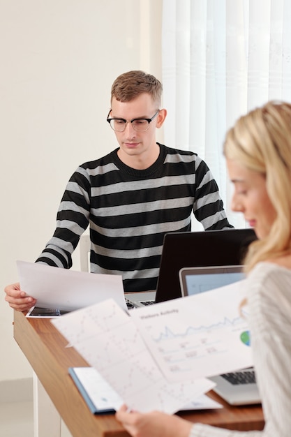 Young couple working with financial documents at table when staying home due to coronavirus pandemic