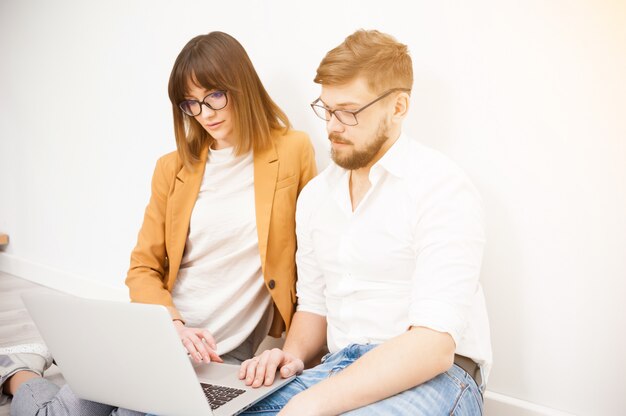 Young coworkers using laptop in office