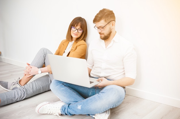 Young coworkers using laptop in office