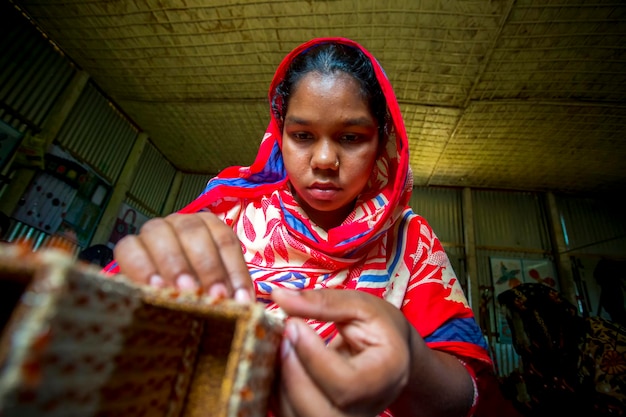 A young crafts maker is making a showpiece from the fibers of a banana tree at Madhupur Tangail Bangladesh