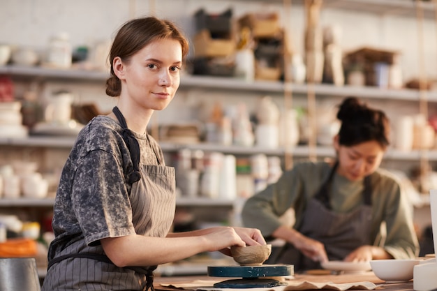 Young craftswoman processing bowl