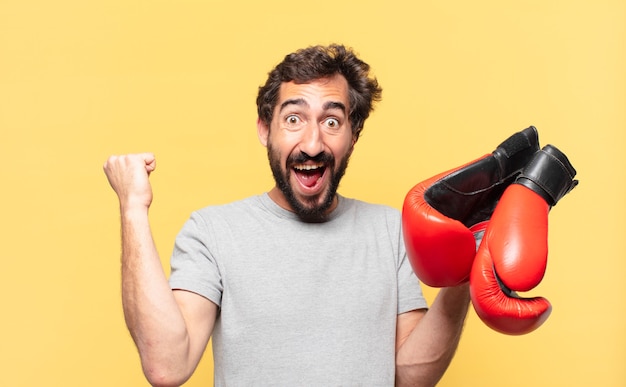 young crazy bearded athlete celebrating successful a victory and holding a boxing gloves