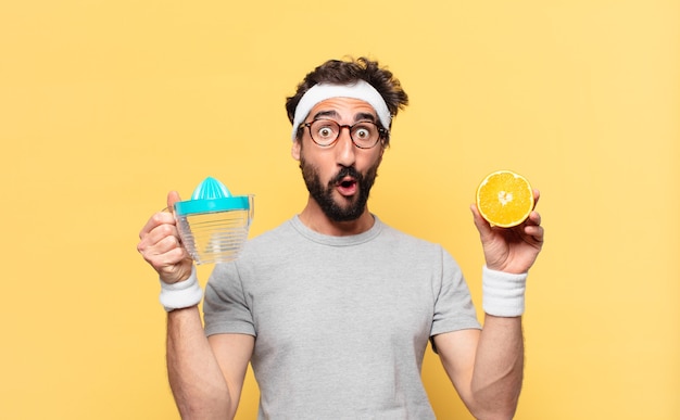 Young crazy bearded athlete scared expression and an orange