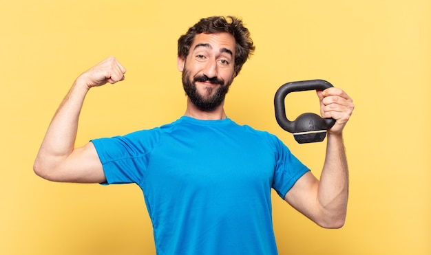 Young crazy bearded athlete young crazy bearded athlete happy expression and lifting a dumbbell