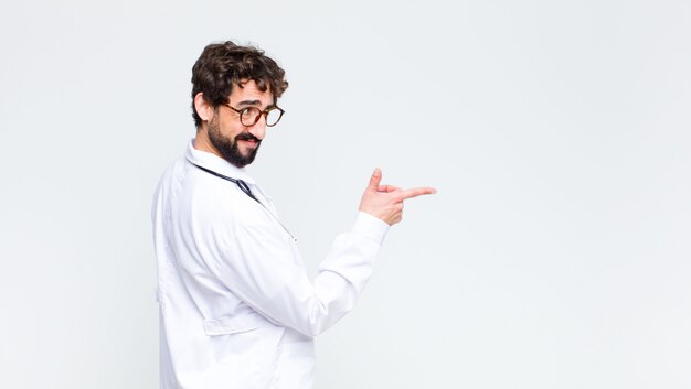 Young crazy bearded doctor man against copy space wall