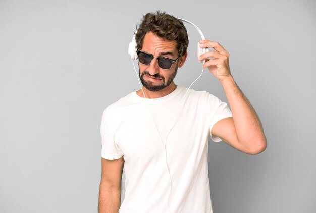 Young crazy bearded and expressive man listening music and\
dancing with headphones