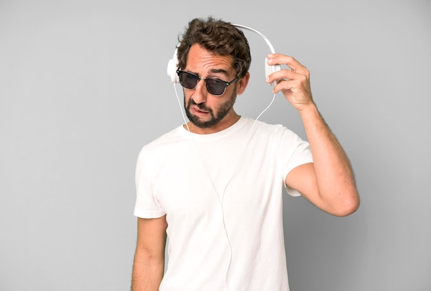 Young crazy bearded and expressive man listening music and\
dancing with headphones