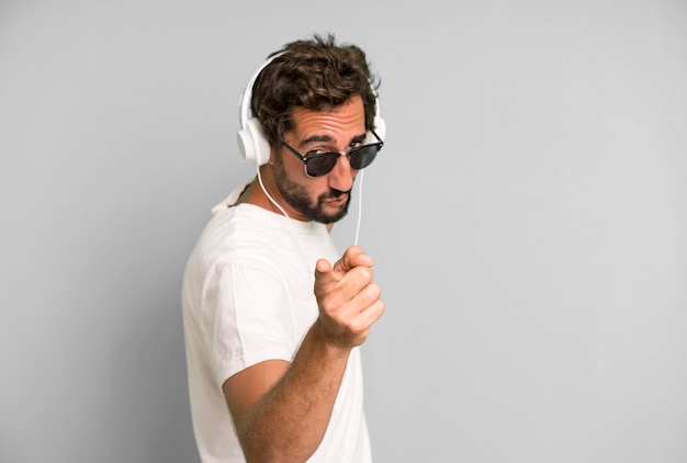 Young crazy bearded and expressive man listening music and\
dancing with headphones
