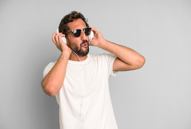 Young crazy bearded and expressive man listening music and\
dancing with headphones