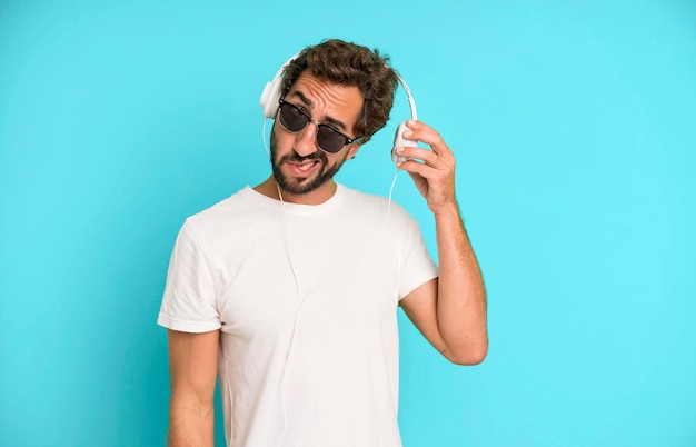 Young crazy bearded and expressive man listening music and\
dancing with headphones