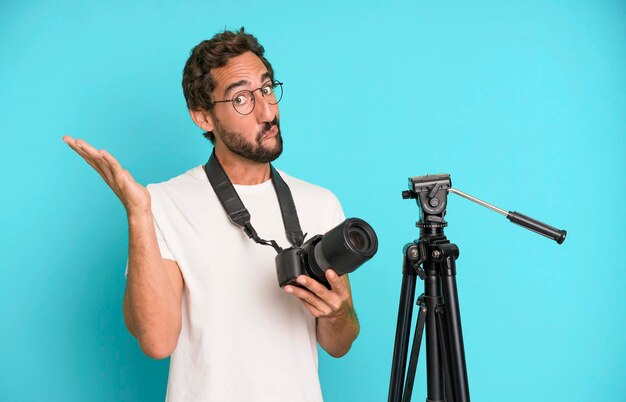 Young crazy bearded and expressive man with a photo camera photographer concept
